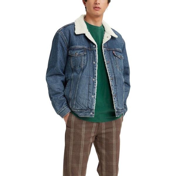 a man wearing a sherpa linked denim trucker jacket over a shirt and pants
