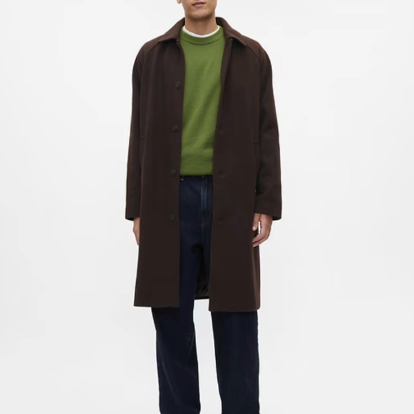 a man wearing a herringbone pattern topcoat over a crewneck shirt and dress pants