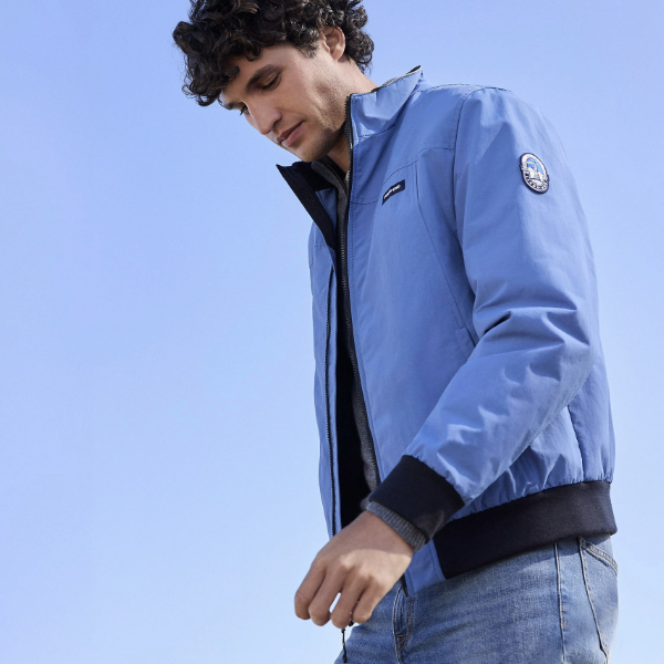 a man wearing an insulated waterproof jacket with denim jeans