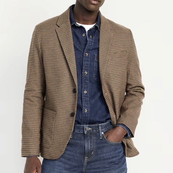 a man wearing a twill blazer over a button front shirt and denim pants