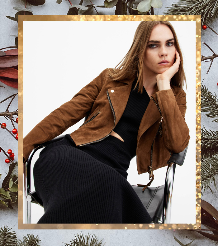 a women wearing a cropped suede leather jacket over a cropped shirt and pants