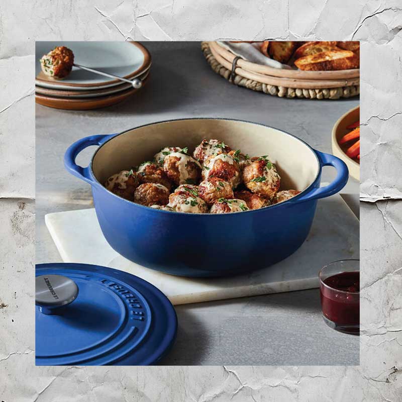 a le creuset dutch oven kitchenware item containing food and placed on a kitchen counter top