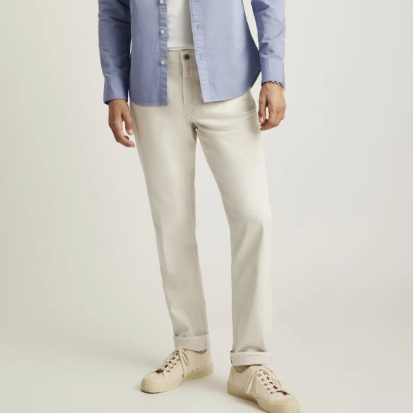 a man wearing five pocket pants with a button front shirt and casual shoes