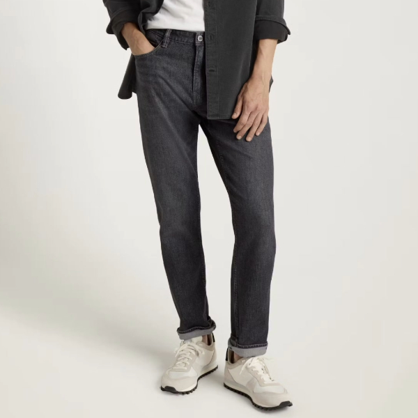 a man wearing denim jeans with casual sneaker shoes