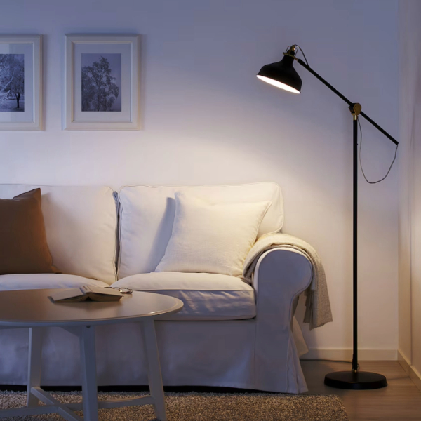 an adjustable floor lamp in a living room space next to a sofa