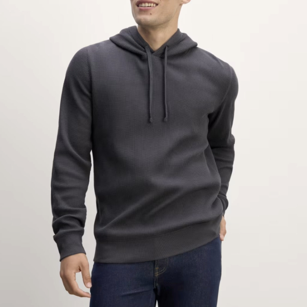 a man wearing a pullover waffle knit hoodie and pants