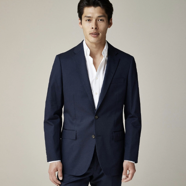 a man wearing an italian suit jacket over a collared dress shirt and dress suit pants