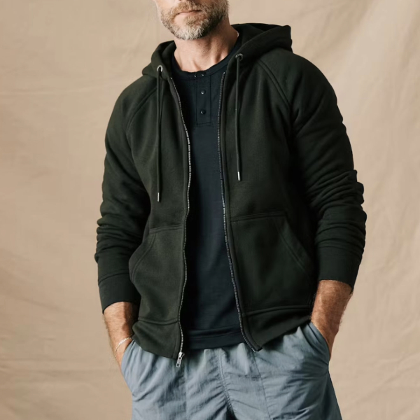 a man wearing a zip front hoodie sweater over cargo pants