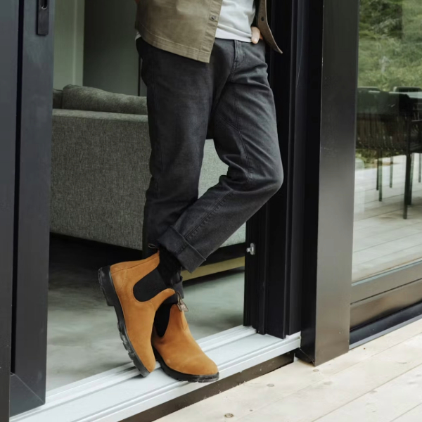 a man wearing chelsea style boots with denim jeans