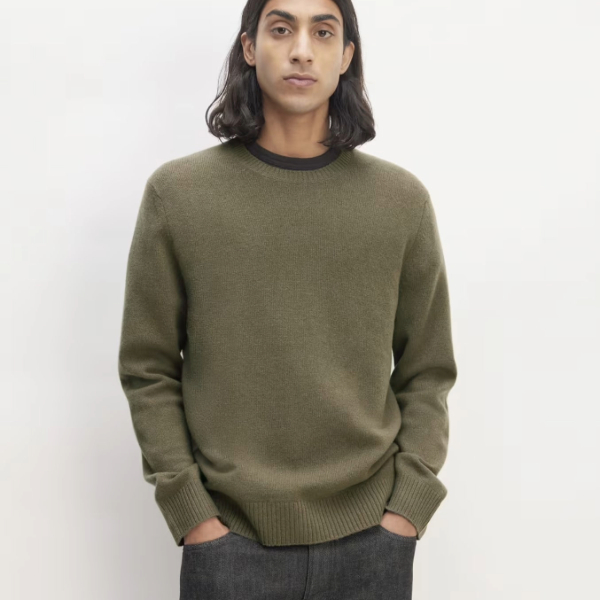 a man wearing a merino wool crew neck sweater and pants