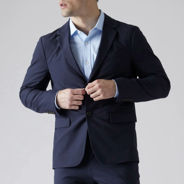 a man wearing a navy blazer over a dress shirt and dress pants