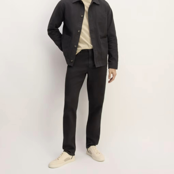 a man wearing tapered jeans with casual shoes and a shirt and jacket