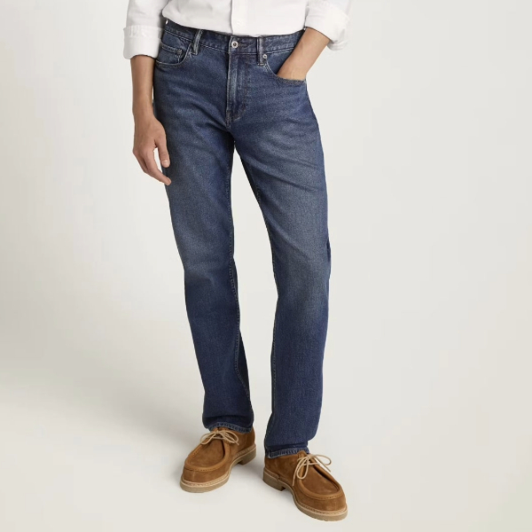 a person wearing classic fit denim jeans with suede boots