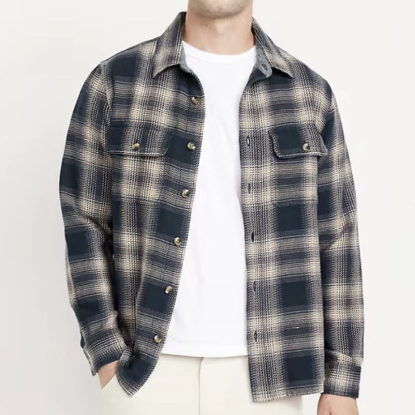 a man wearing a plaid long sleeve buttond down shirt over a crew neck shirt