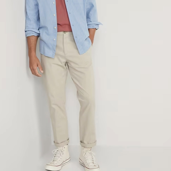 a man wearing chino pants with an unbuttoned shirt and high top sneakers