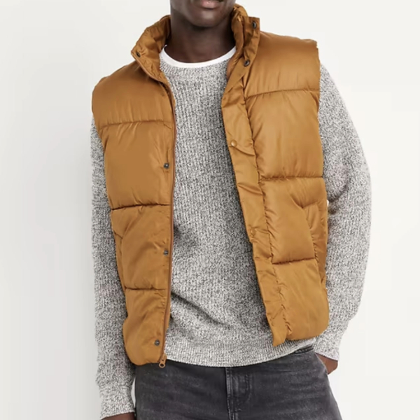 man wearing a water resistant puffer vest over a sweater and denim pants
