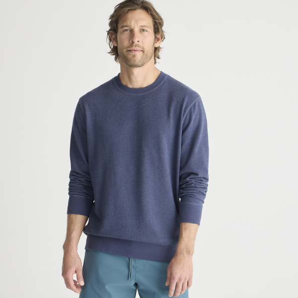 man wearing a sweater shirt over denim jeans