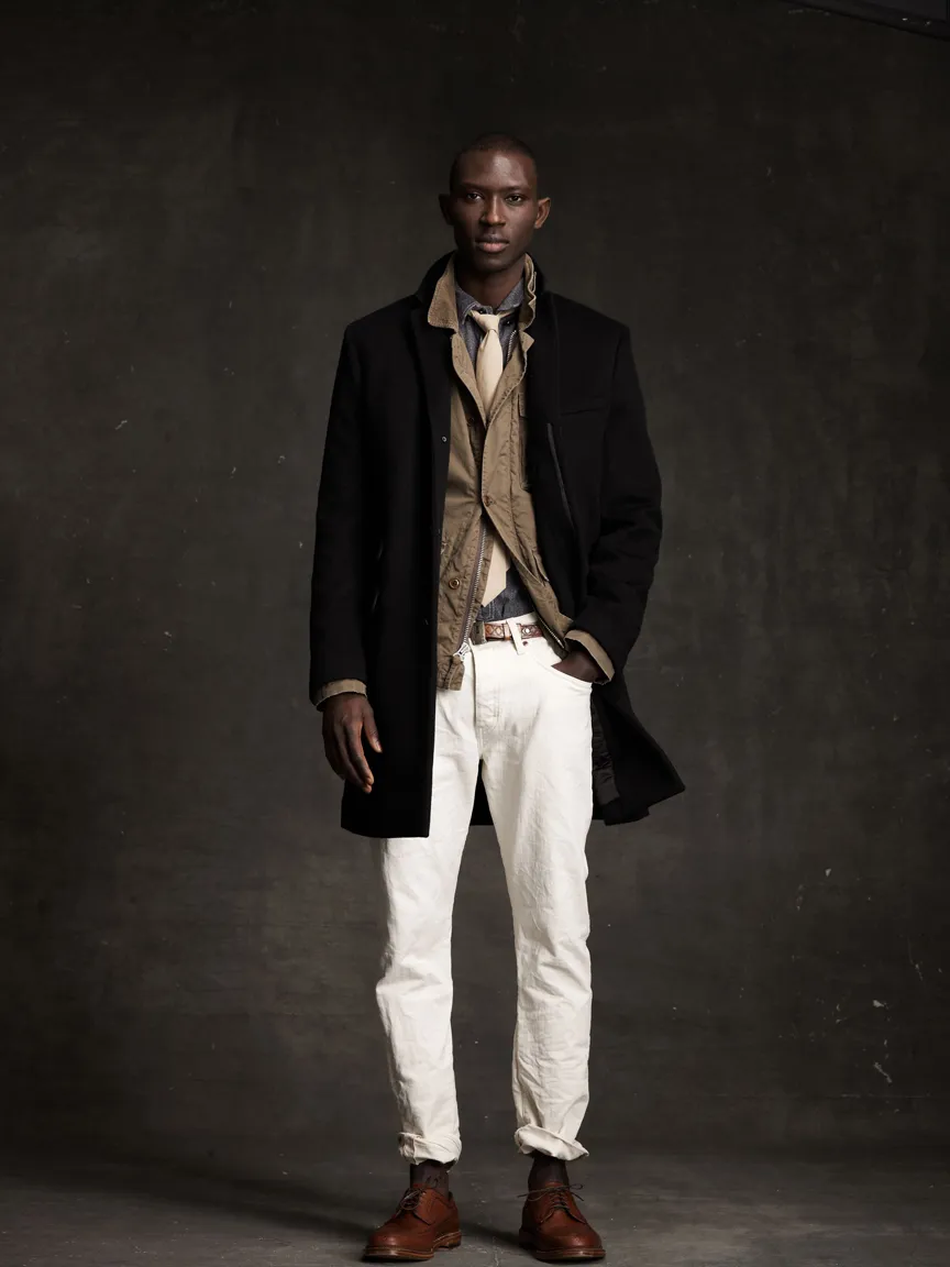 model for jcrew wearing a top coat with a light tie and low rise skinny white jeans