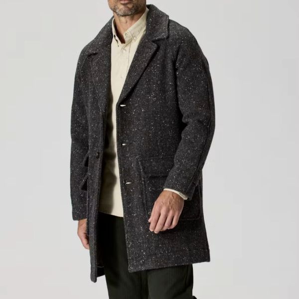 man wearing a wool herringbone overcoat over a button down shirt and pants