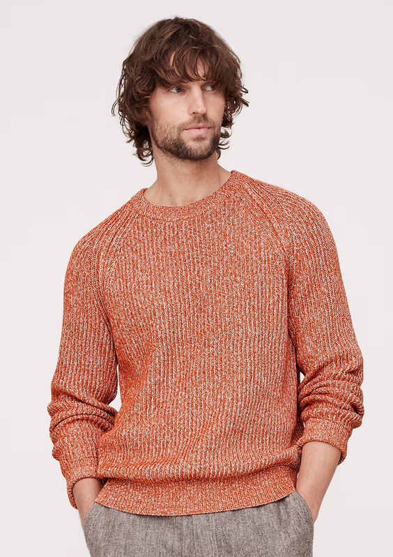 man wearing a salmon colored ribbed crew neck sweater