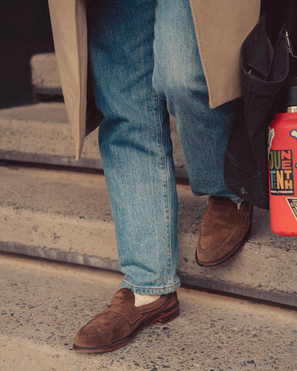 close up of light wash denim and suede loafers