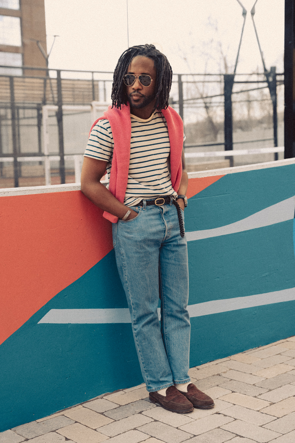 daniel wearing a striped t-shirt with a sweater draped over his shoulders