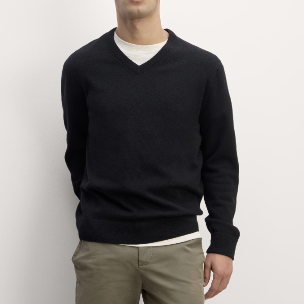 man wearing a cashmere crewneck sweater over a crew neck shirt and pants