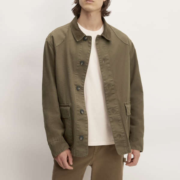 man wearing utility barn style jacket over a crew neck sweater and chino pants