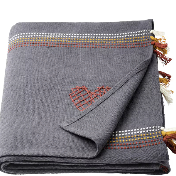 a hand woven embroidered throw blanket with tassels around the edges