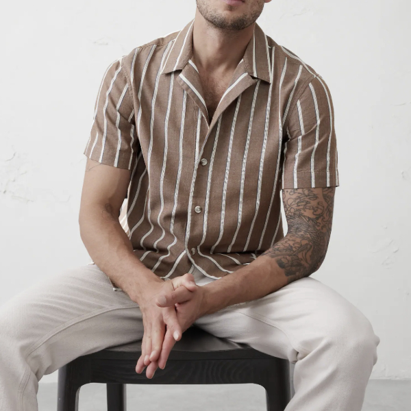 man wearing a striped resort style shirt with short sleeves and pants