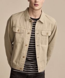 man wearing a linen trucker style jacket over a striped shirt