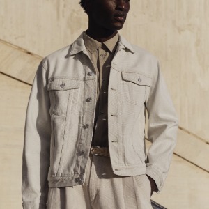 man wearing a beige colored trucker style jacket