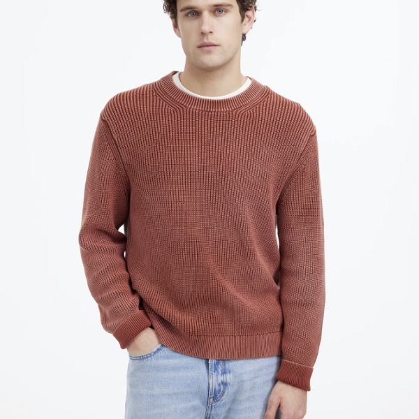 man wearing a shaker stitch crewneck sweater and denim jeans
