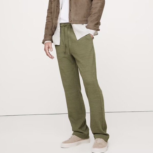 man wearing a slub beach pant with an unbuttoned shirt and casual sneaker shoes