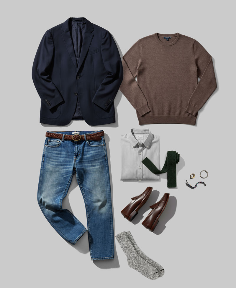 outfit layout with the following pieces: blazer jacket, crewneck sweater, jeans with a belt, collared button up shirt, tie, socks, loafers, assorted accesories