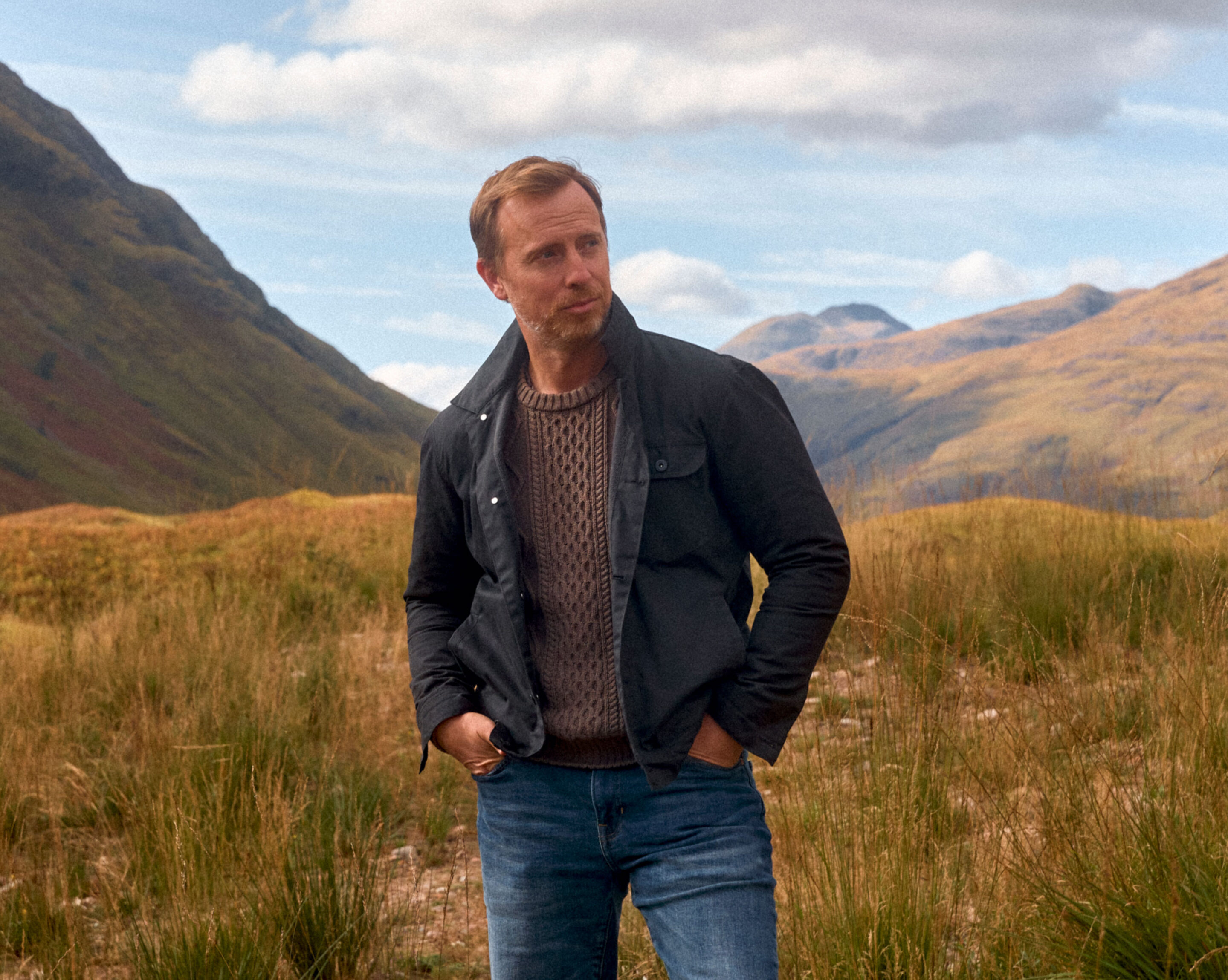 mens fall outfit idea with black jacket and brown cable knit sweater featuring thursday boot co waxed canvas jacket
