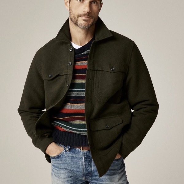 man wearing a utility over shirt over a sweater and denim jeans