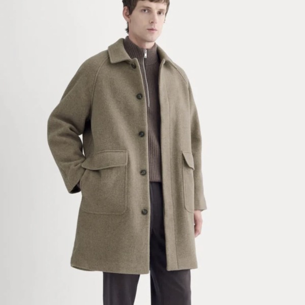 man wearing a car coat over shirt and pants