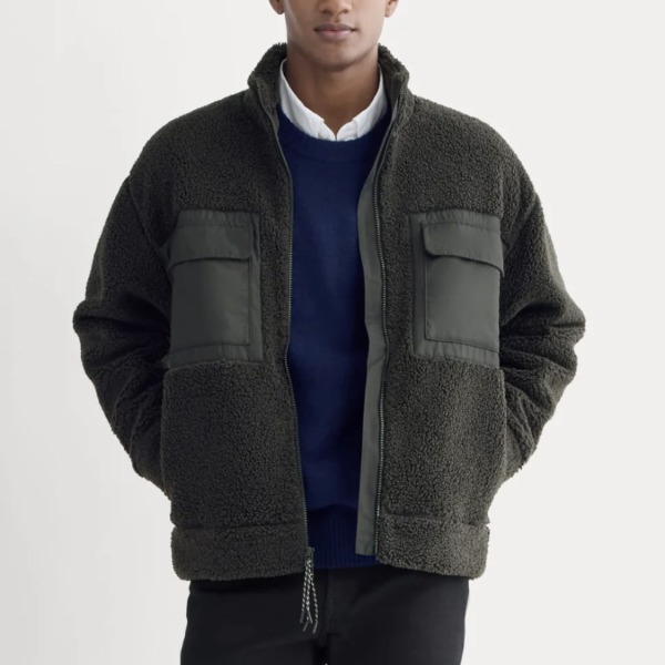 man wearing a fleece zip up jacket over a sweater and pants