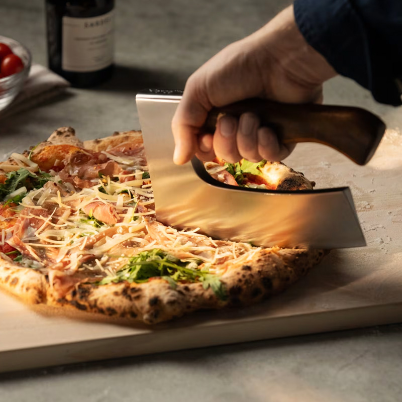 cutting pizza with a large ax like blade